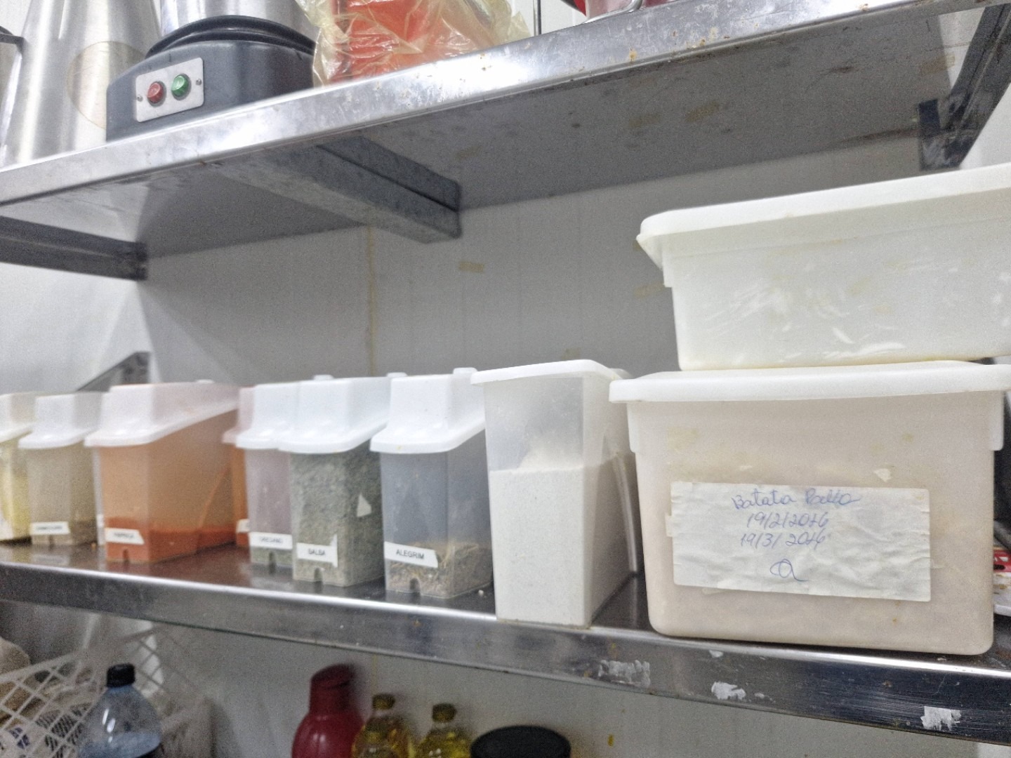 Cozinha com etiquetas escritas à mão em potes plásticos — processo manual e despadronizado